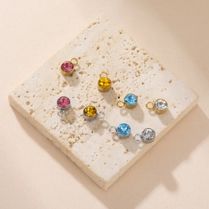 Close-up of assorted colorful crystal pendants on a travertine stone display