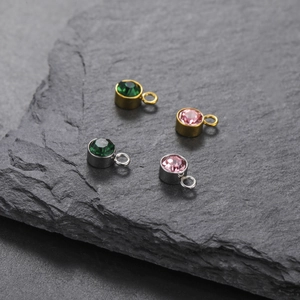 Detailed macro shot of round birthstone charms with gold and silver bezel settings