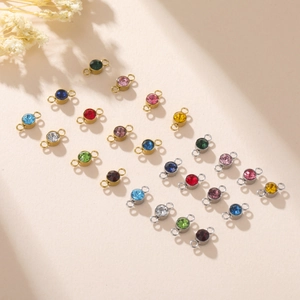 Macro view of crystal birthstone connectors with gold and silver plated double rings