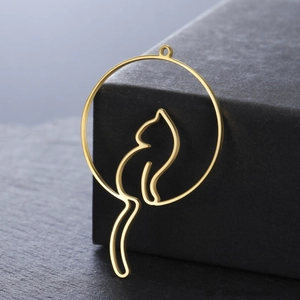 Hollow cat silhouette stainless steel 18K gold pendant on a dark stone background