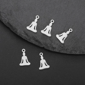 Dettaglio macro di cinque ciondoli yoga in acciaio inossidabile argento su pietra di ardesia