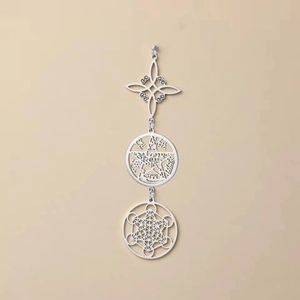 Dettaglio dei ciondoli a nodo celtico e cubo di Metatron in argento con design a tre strati