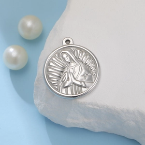 Detail showing an embossed silver praying figure on a round stainless steel pendant