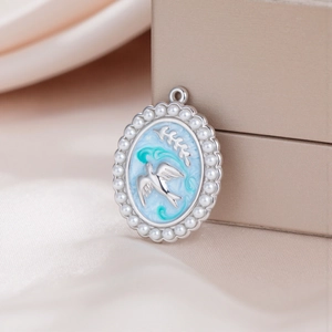 Detail of oval stainless steel dove pendant with blue enamel and pearl border on satin