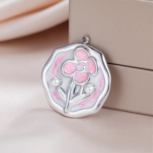 Detailed view of silver flower pendant with pink enamel petals and pearl accents on silk