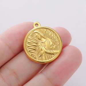 Golden round Virgin Mary pendant in stainless steel held to show product size and scale