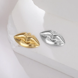 Poliertes Lippenanhänger-Set aus Edelstahl in Gold und Silber auf Stein