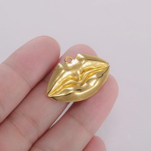 Nahaufnahme eines goldenen Lippen-Metallanhängers mit Textur für DIY-Schmuckherstellung