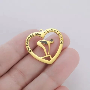 Close-up of heart-shaped gold pendant with swimming figure and engraved inspirational quote