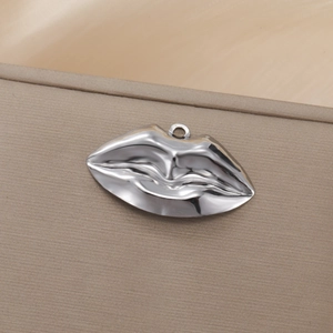 Detailaufnahme eines silbernen Lippen-Anhängers aus Edelstahl mit Hochglanzpolitur-Oberfläche
