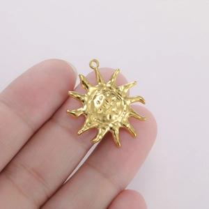 Makroaufnahme eines goldenen Sonnen-Anhängers mit Gesicht für DIY-Schmuckherstellung