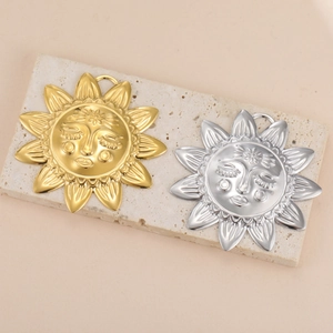Goldene und silberne Sonnenanhänger im Boho-Stil auf einer Travertin-Präsentationsplatte