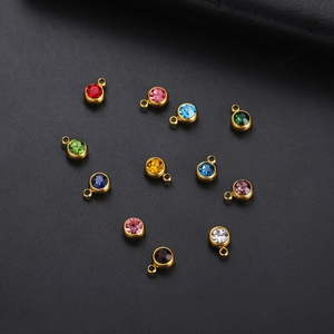 Macro shot of twelve assorted colorful round birthstone pendants with gold plating finish