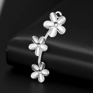 Détail macro du pendentif fleur en acier inoxydable poli sur support cuir noir