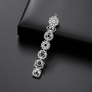 Vue détaillée de sept symboles de chakra sur un pendentif en acier inoxydable