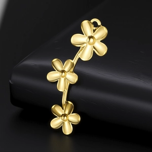 Vue macro d'un pendentif fleur dorée avec finition métallique polie sur cuir noir