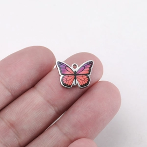 Macro detail of colorful printed butterfly stainless steel pendant for jewelry DIY