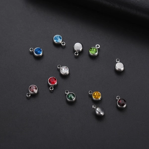 Macro shot of colorful round crystal pendants with silver stainless steel bezels and loops
