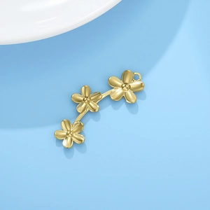 Détail de trois pendentifs fleurs en acier inoxydable doré pour création de bijoux