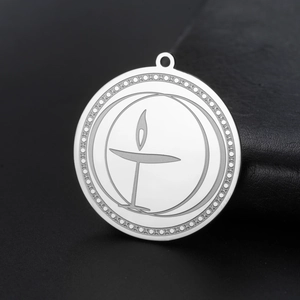 Macro shot of stainless steel flaming chalice pendant with intricate cross pattern engraving