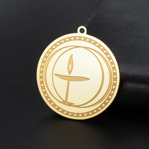 Macro shot of gold stainless steel flaming chalice pendant with geometric engraved edge