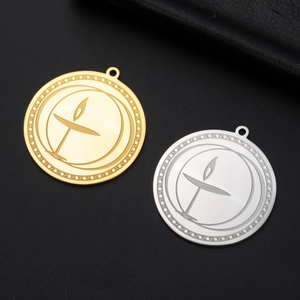 Macro shot of gold and silver burning chalice charms with moon outline engraving