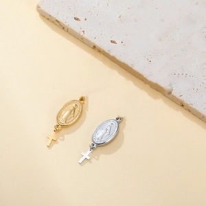Gros plan de breloques religieuses en acier inoxydable avec portrait et croix or et argent
