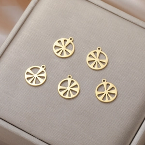 Macro shot of five gold hollow lemon slice charms for DIY jewelry making in a grey box