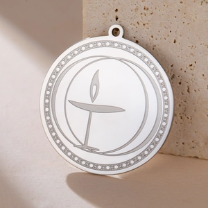 Polished stainless steel chalice fire pendant on stone background for DIY jewelry
