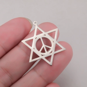 Polished silver stainless steel hexagram pendant with peace symbol in hand for scale