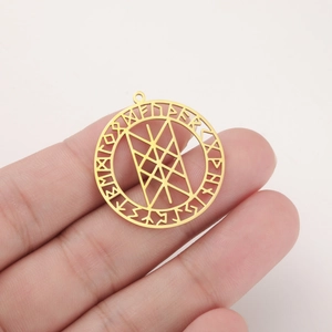 Detailopname van een gouden geometrische hanger met gegraveerde Noorse runensymbolen