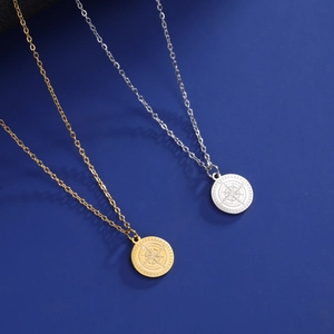 Details der Kompass-Anhänger in Gold und Silber mit Sternrelief und O-Kette