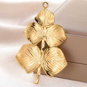 Golden leaf-shaped stainless steel pendant with realistic texture on a silk background