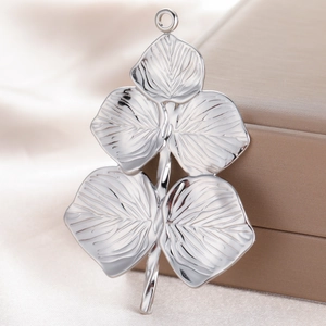 Polished silver stainless steel leaf pendant on luxury silk background with top ring loop