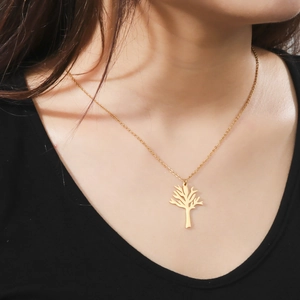 Elegant gold tree of life branch pendant necklace on female model neck in close-up shot