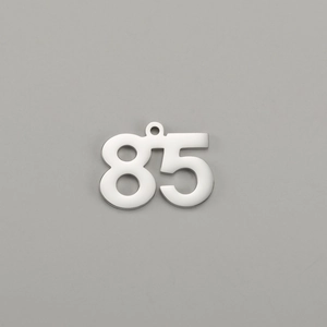 Detailed macro view of polished number 85 stainless steel pendant with hanging loop
