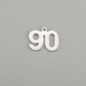 Detailed macro shot of polished stainless steel number 90 charm pendant with mirror finish