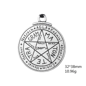 Macro view of vintage silver amulet pendant with engraved pentagram and mystic inscriptions