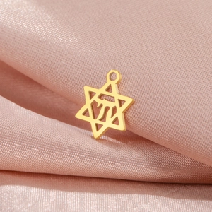 Vue détaillée du pendentif étoile de David en acier doré sur un fond en satin rose
