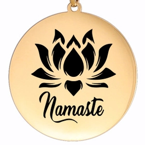 Détail macro du pendentif lotus en acier doré avec gravure Namaste pour bijoux de yoga