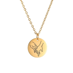 Detailed view of gold round pendant necklace with pinky promise engraving on white background