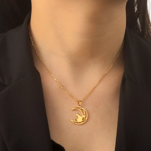 Dettaglio della collana in oro 18K con ciondolo a luna e gatto su una modella