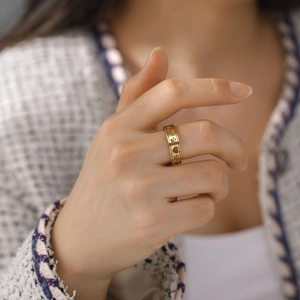Golden stainless steel ring featuring engraved heart and paw patterns on a model's finger