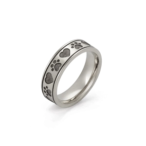Macro detail of stainless steel ring showing engraved heart and paw prints patterns