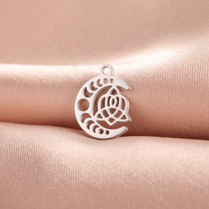 Silver crescent moon pendant with rose cutout on pink satin background