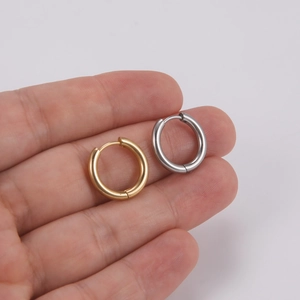 Polished 18K gold plated and silver stainless steel hoop earrings held in hand