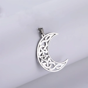 Macro detail of silver moon pendant with cutout celtic knot and pentagram star