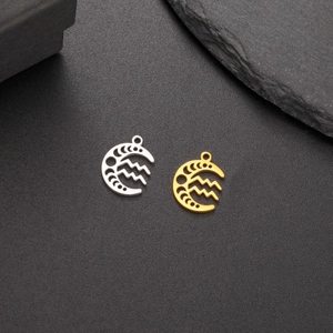 Macro view of gold and silver moon pendants with Aquarius zodiac hollow design