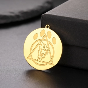 Detail of a golden stainless steel wolf head pendant with geometric engraved patterns