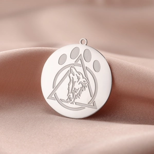 Macro detail of stainless steel wolf head pendant with geometric engraving on silk